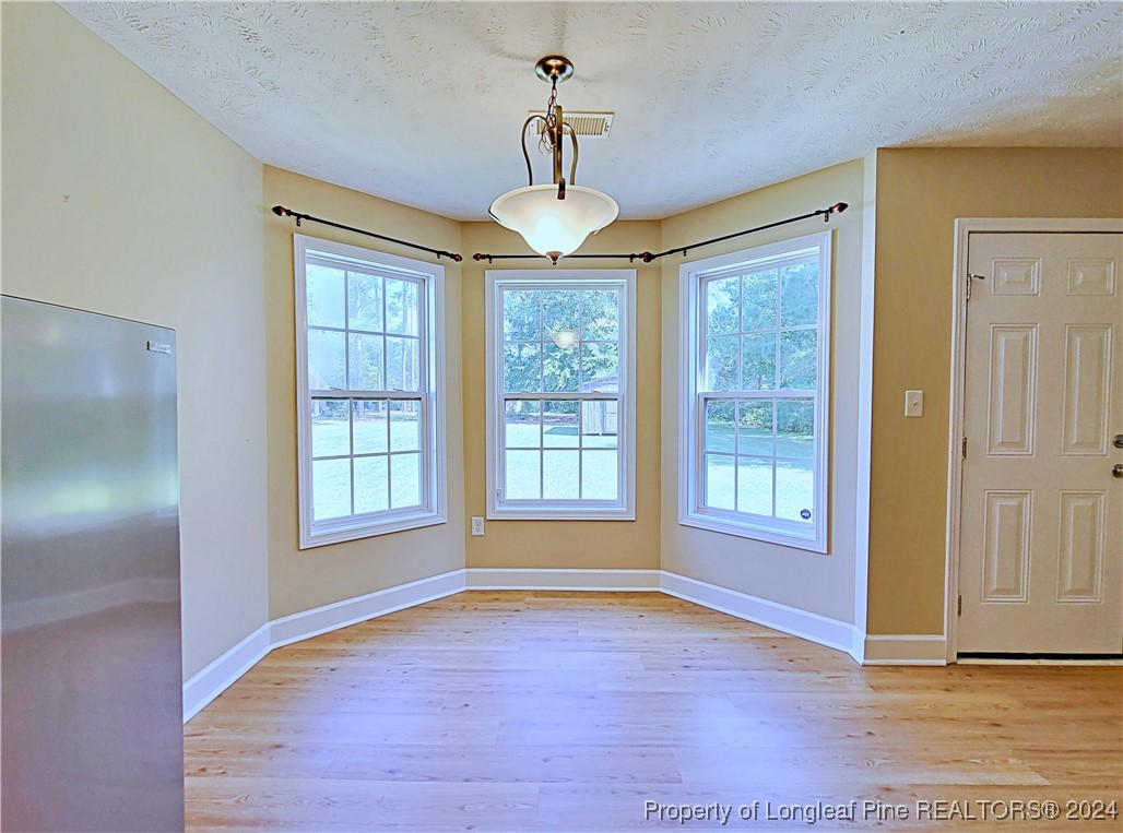 235 Chestnut Drive Raeford, NC 28376 - Photo 14 of 50 a view of an empty room with wooden floor and a window