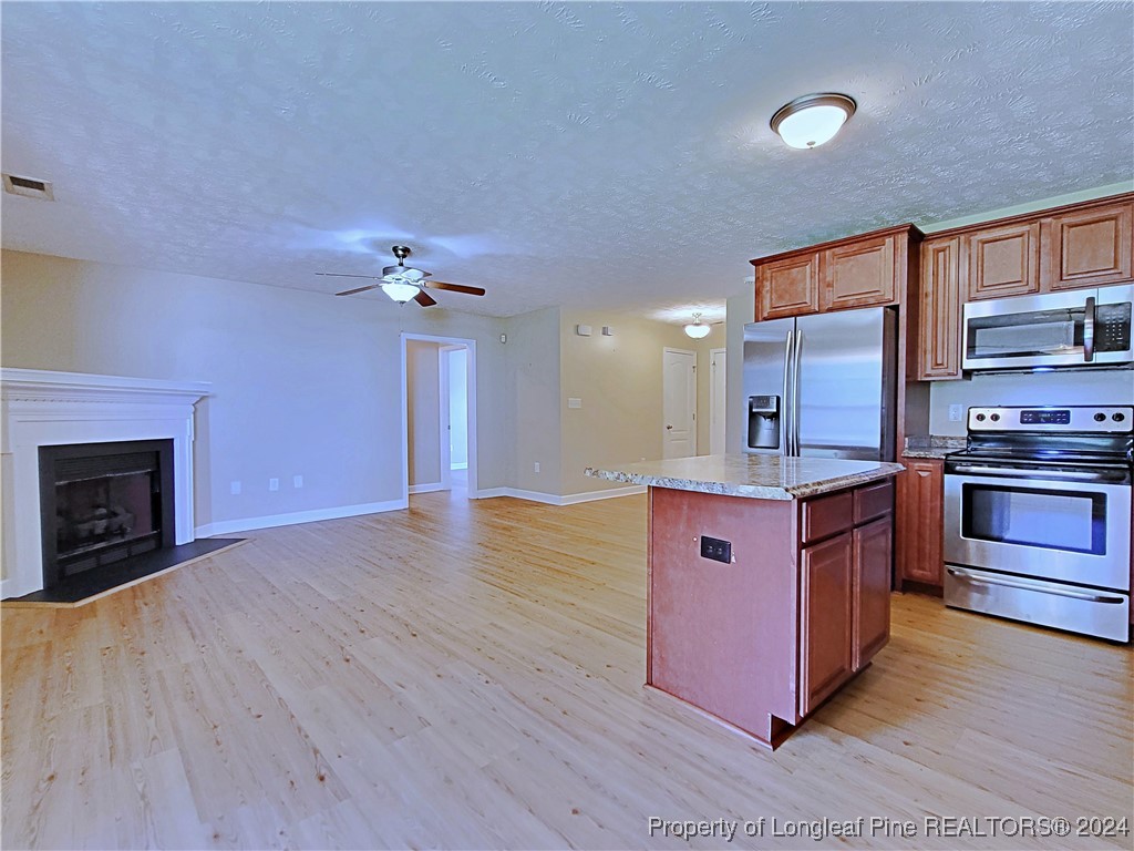 235 Chestnut Drive Raeford, NC 28376 - Photo 16 of 50 a kitchen with stainless steel appliances kitchen island granite countertop a stove a sink and a refrigerator