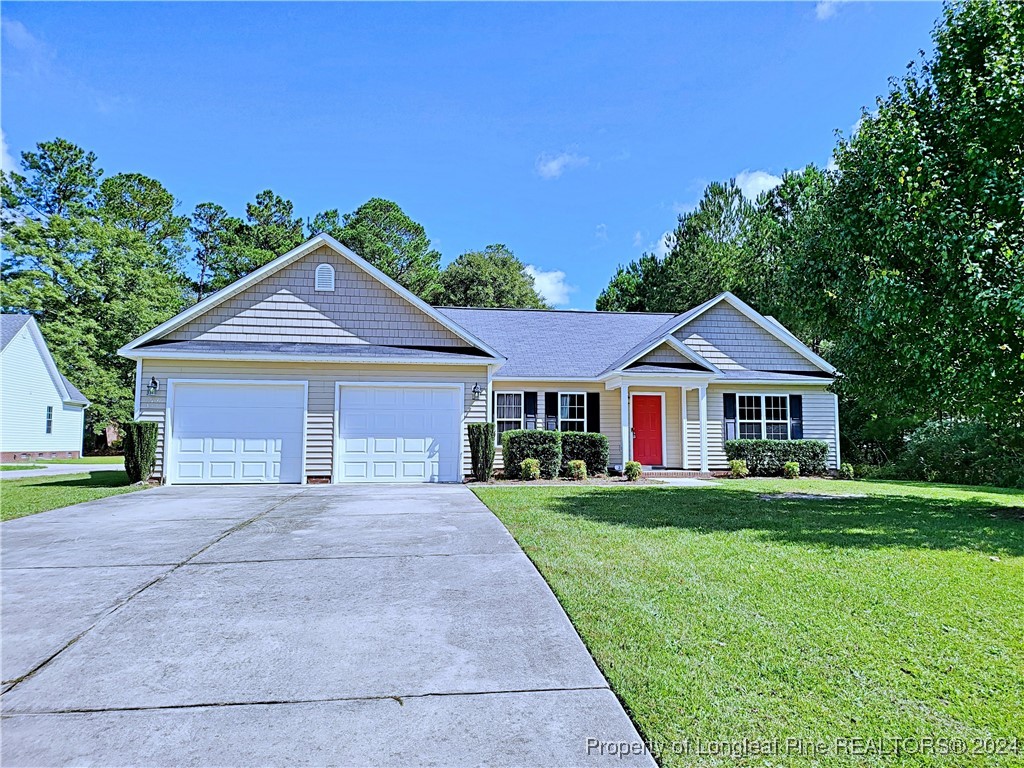 235 Chestnut Drive Raeford, NC 28376 - Photo 2 of 50 a front view of a house with a yard and garage