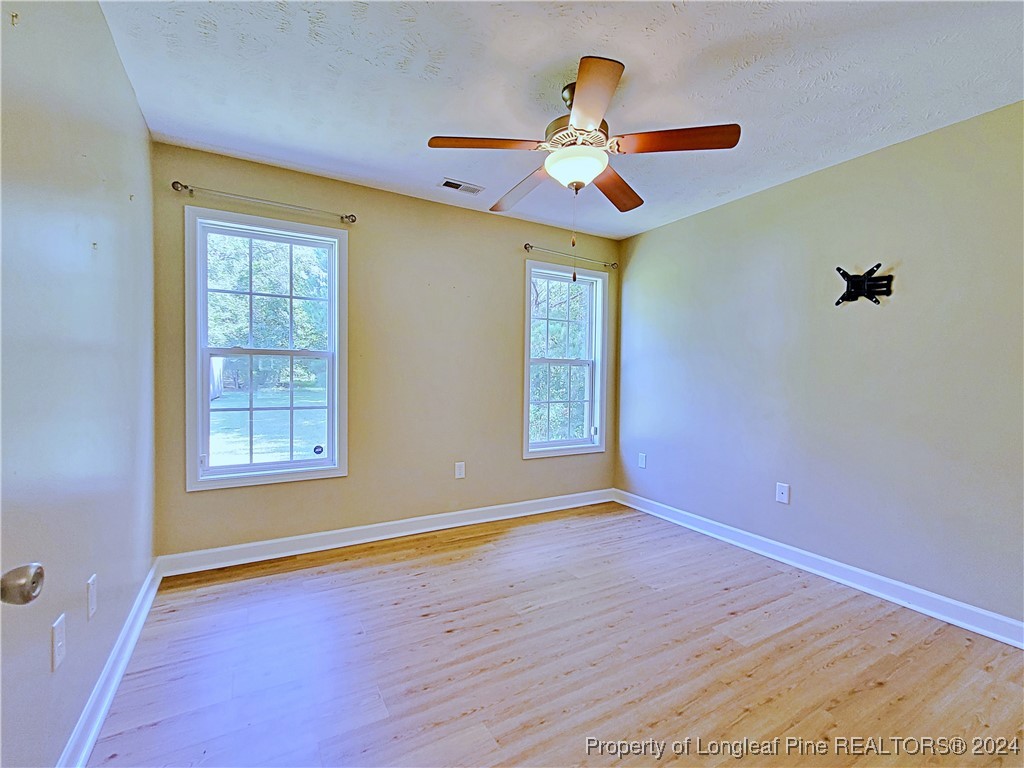 235 Chestnut Drive Raeford, NC 28376 - Photo 40 of 50 a view of an empty room with window and chandelier fan
