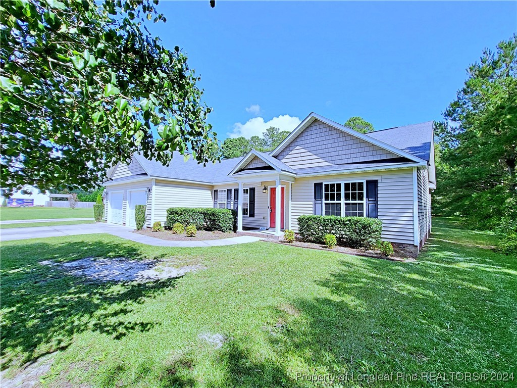235 Chestnut Drive Raeford, NC 28376 - Photo 4 of 50 a front view of a house with a garden