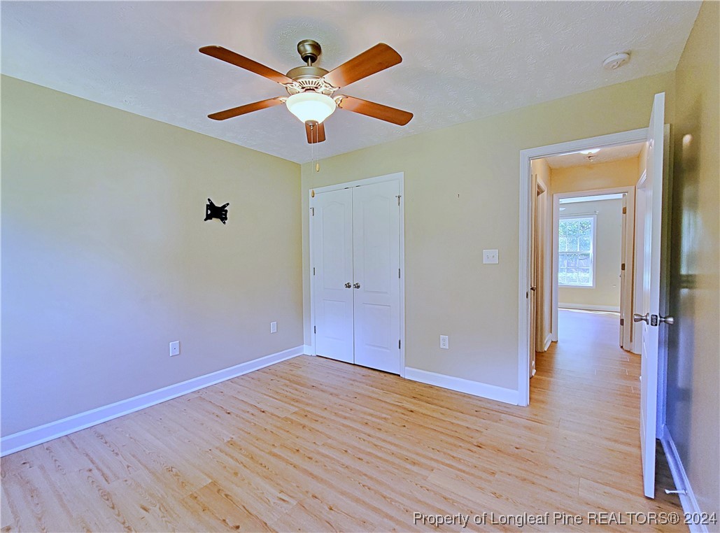 235 Chestnut Drive Raeford, NC 28376 - Photo 41 of 50 an empty room with wooden floor and a ceiling fan