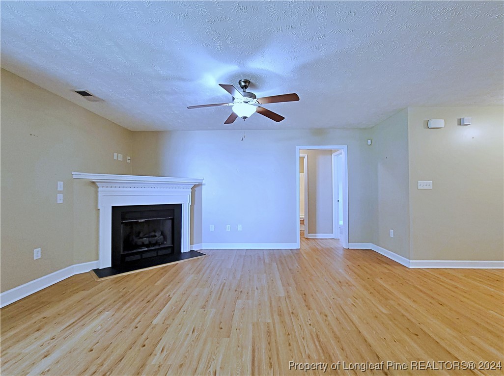 235 Chestnut Drive Raeford, NC 28376 - Photo 10 of 50 a view of empty room with wooden floor and a fireplace