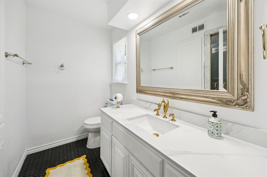 11212 Inwood Road Dallas, TX 75229 - Photo 25 of 36 a bathroom with a sink a toilet and a mirror