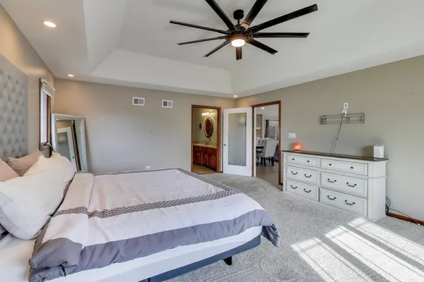 a bedroom with a large bed and a chandelier