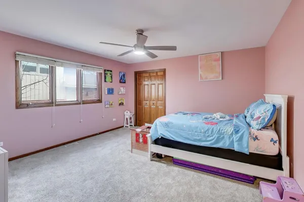 a bedroom with a bed and a chandelier fan