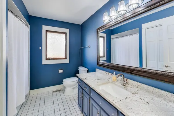 a bathroom with a sink double vanity granite and a toilet