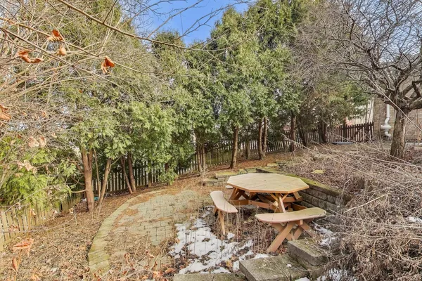 a view of a backyard with table and chairs and wooden fence