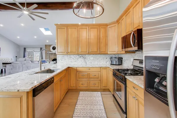 a kitchen with stainless steel appliances granite countertop a sink stove and cabinets