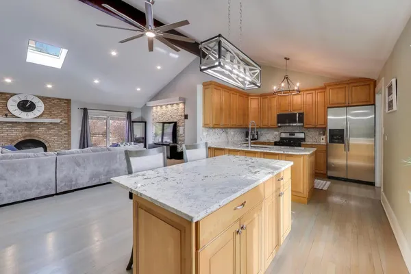 a kitchen with a center island appliances and cabinets