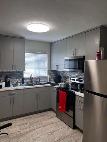a kitchen with granite countertop stainless steel appliances and wooden cabinets
