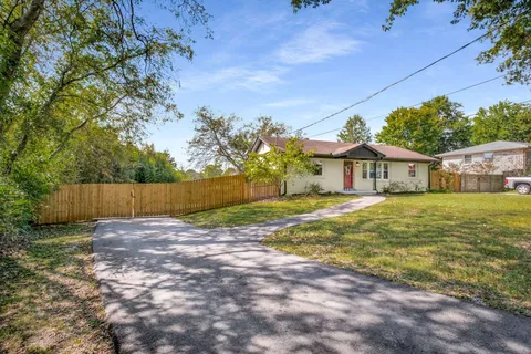 a view of a house with backyard and a tree