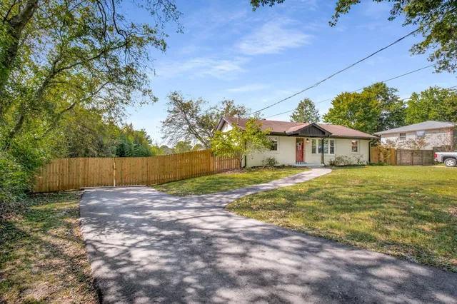 a view of a house with backyard and a tree