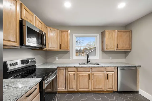 a kitchen with stainless steel appliances granite countertop a stove a refrigerator and a microwave