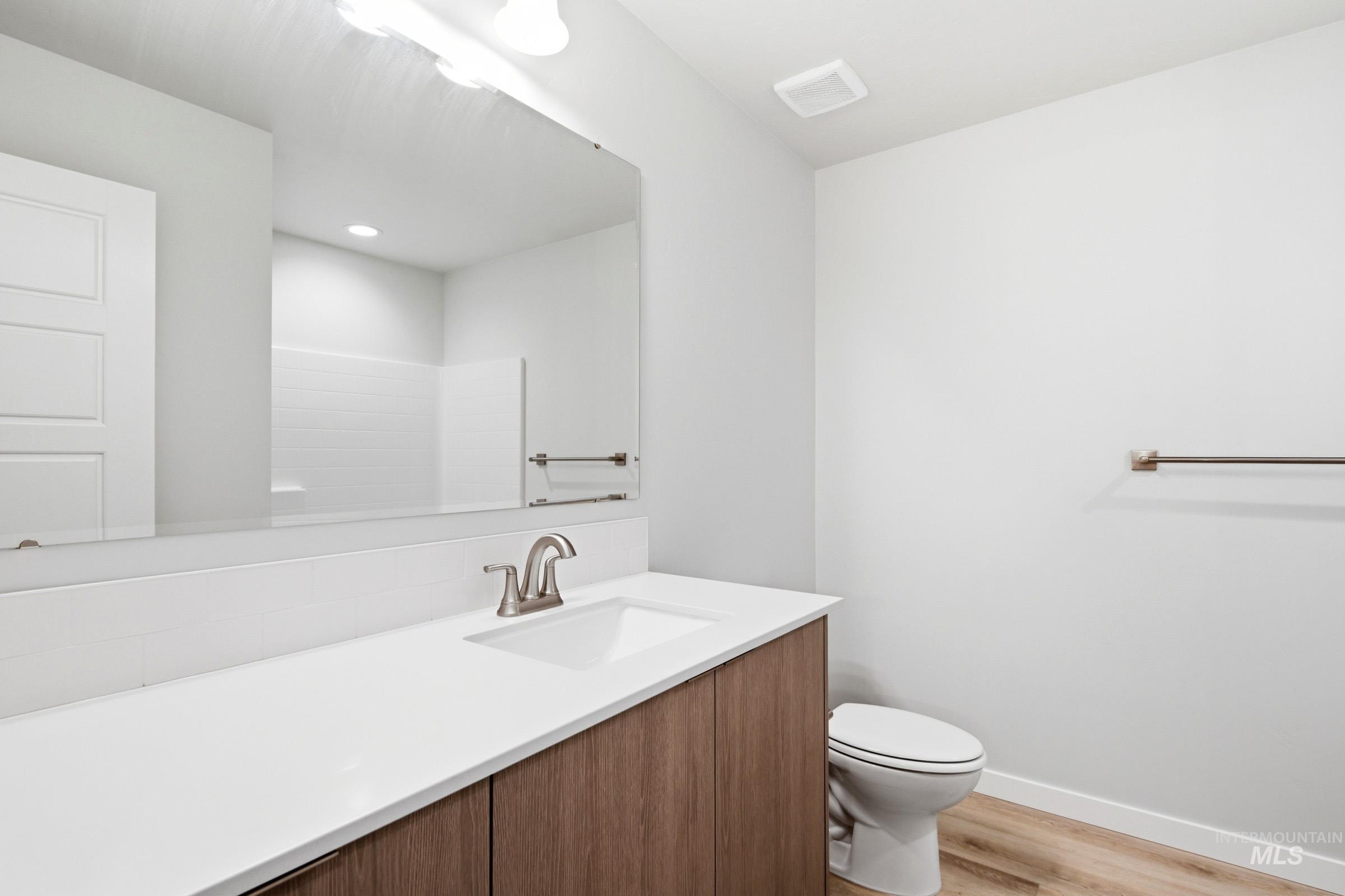 10800 Rutland Street Caldwell, ID 83605 - Photo 15 of 21 Contemporary bathroom vanity featuring a white countertop with an integrated sink and brushed nickel faucet