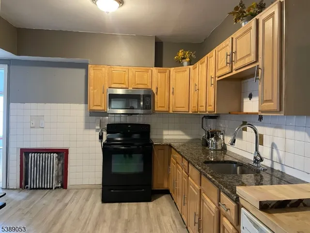 a kitchen with granite countertop a stove a sink and a microwave
