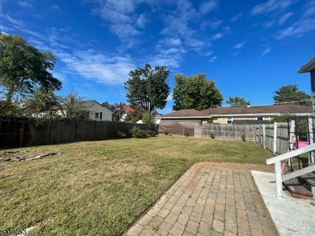 a view of a patio with table and chairs and wooden fence