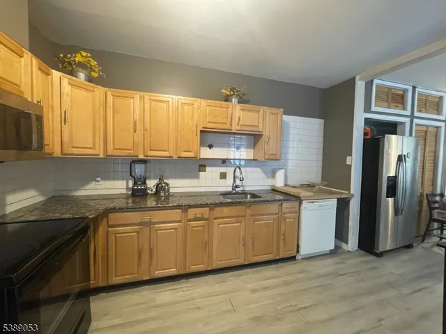 a kitchen with stainless steel appliances granite countertop a sink and a stove