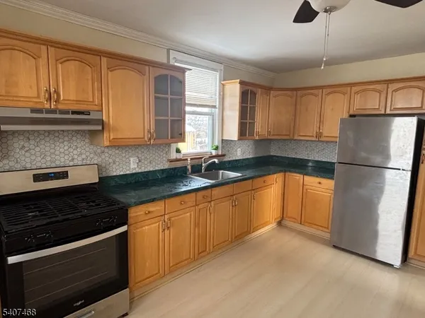 a kitchen with granite countertop a refrigerator sink and cabinets