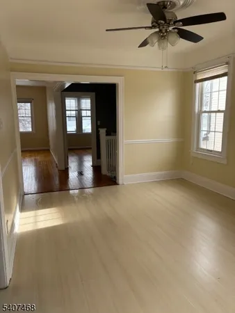 an empty room with fan and windows