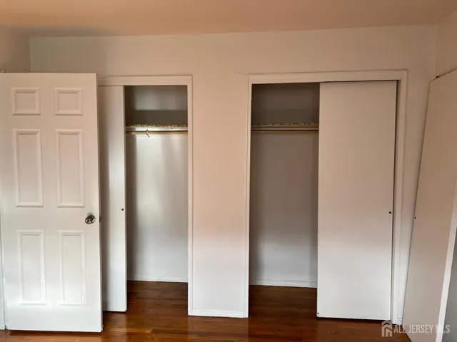 an empty room with wooden floor and closet