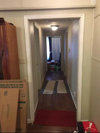 a view of a hallway with wooden floor and staircase