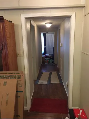 a view of a hallway with wooden floor and staircase