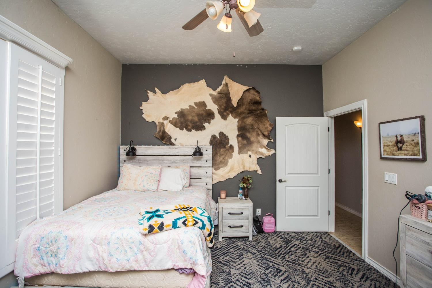7516 66th Street Lubbock, TX 79407 - Photo 25 of 50 a bedroom with a bed and a chandelier