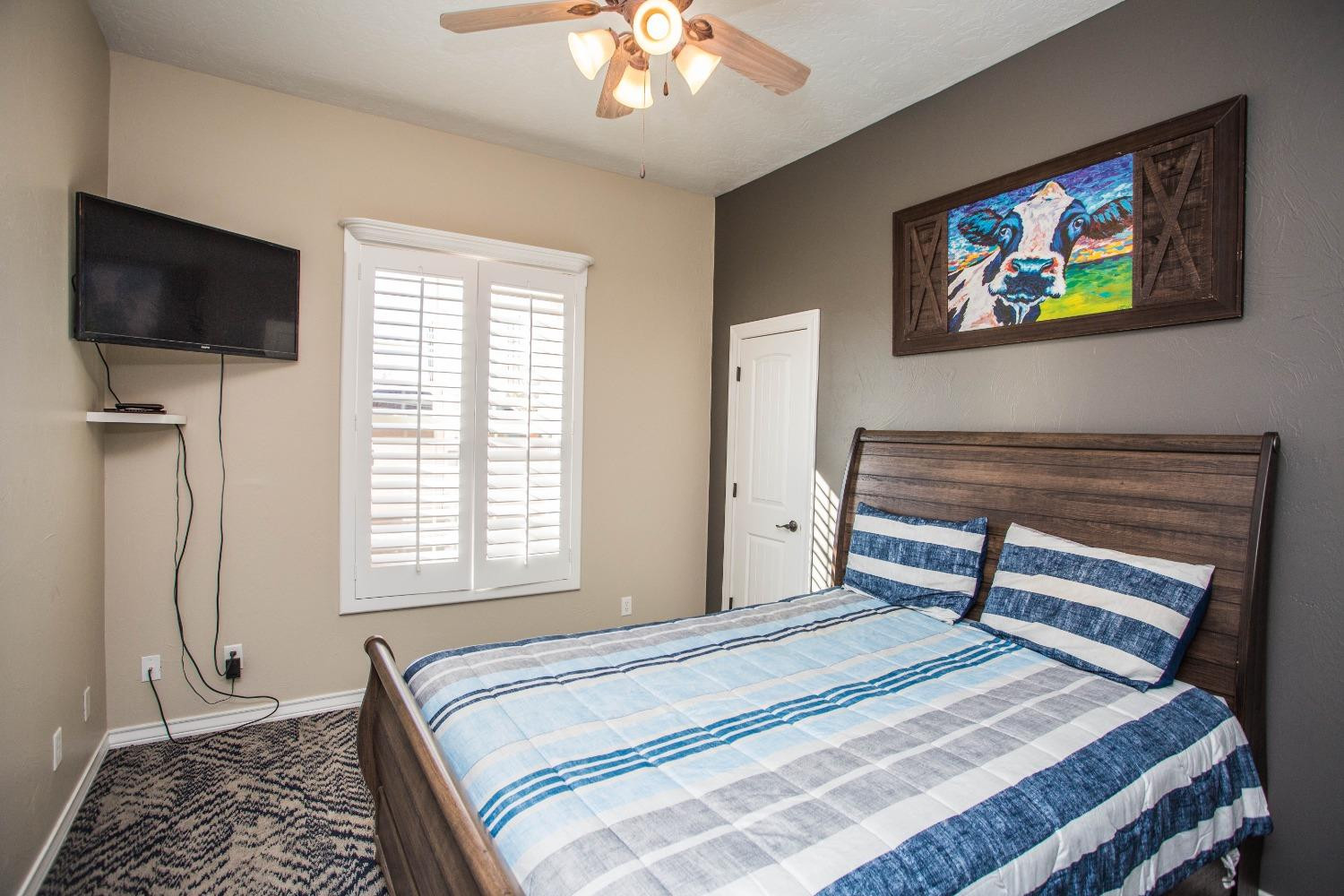 7516 66th Street Lubbock, TX 79407 - Photo 28 of 50 a bedroom with a bed and a flat screen tv