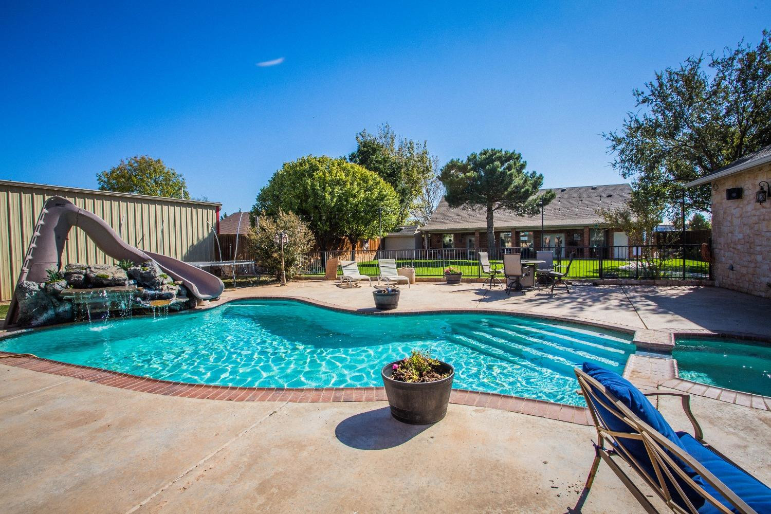 7516 66th Street Lubbock, TX 79407 - Photo 39 of 50 a view of a swimming pool with a patio and a garden