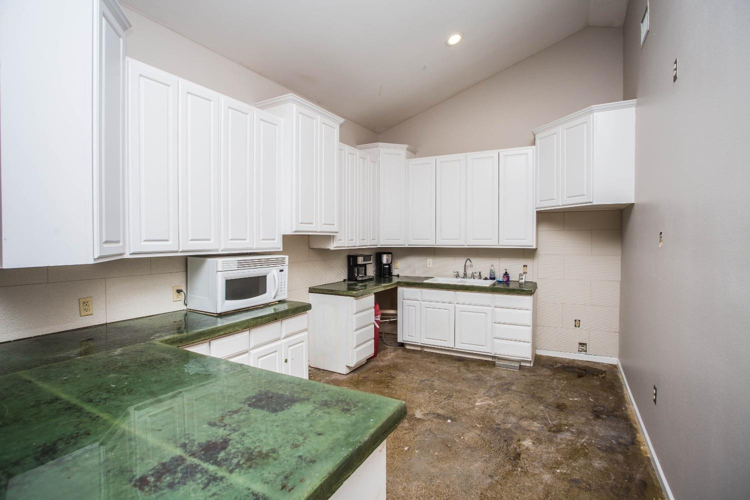 7516 66th Street Lubbock, TX 79407 - Photo 45 of 50 a kitchen with granite countertop a stove sink and cabinets
