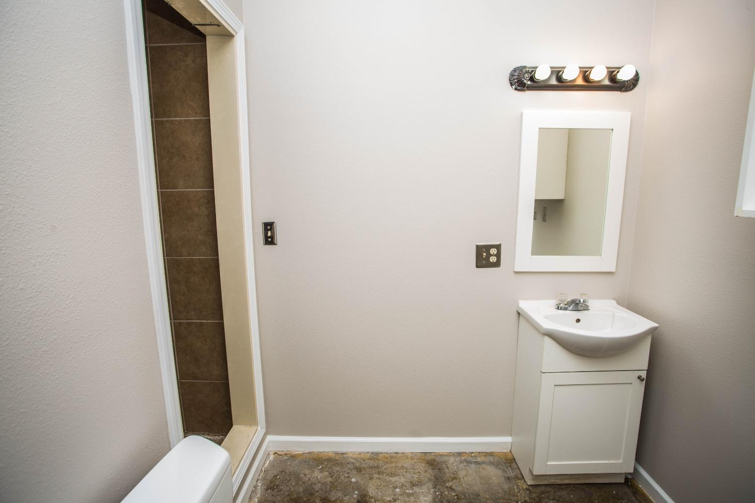 7516 66th Street Lubbock, TX 79407 - Photo 46 of 50 a bathroom with a sink a toilet and mirror
