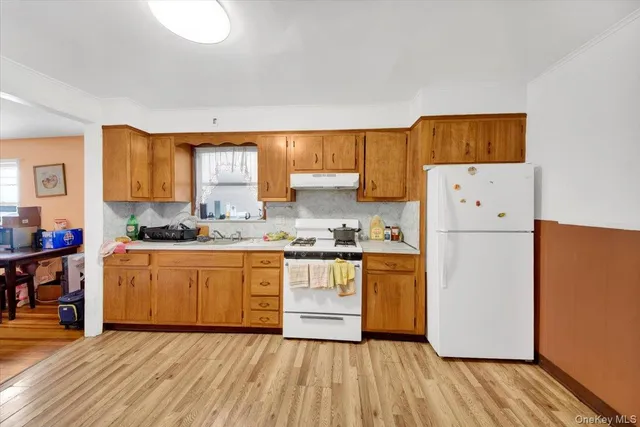 a kitchen with granite countertop a refrigerator and a stove top oven