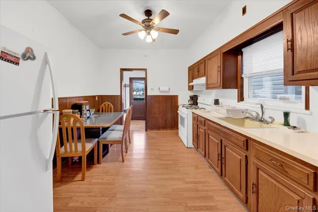 a large kitchen with stainless steel appliances granite countertop a sink and a refrigerator