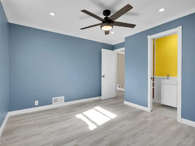 an empty room with a window and a ceiling fan