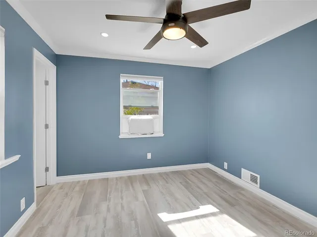 an empty room with a window and a ceiling fan