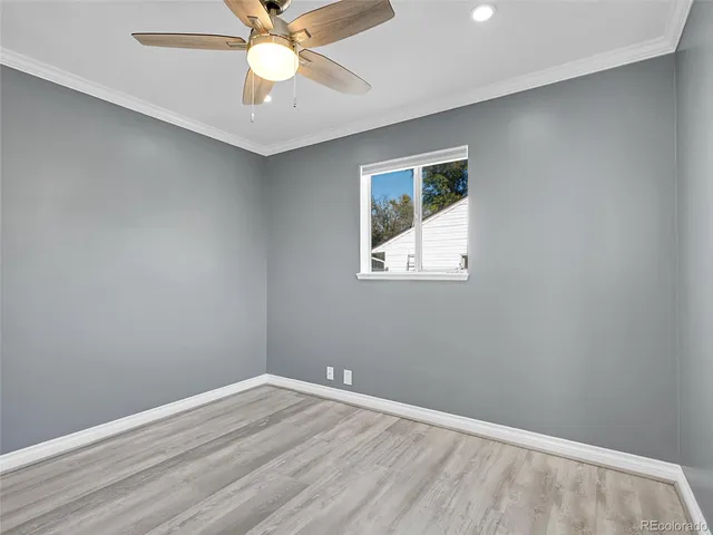an empty room with a window and a fan