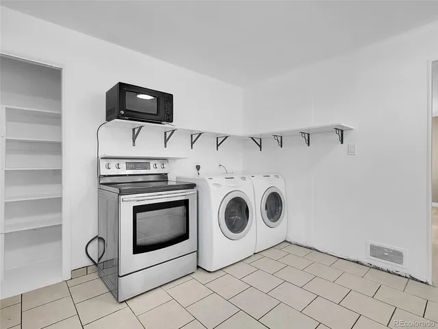 a utility room with dryer washer and a view of living room