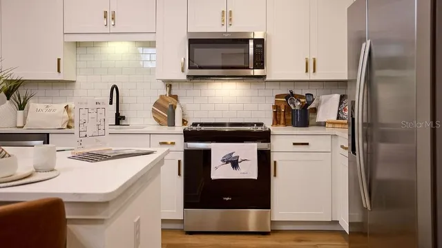 a kitchen with kitchen island a counter space a sink a stove and refrigerator