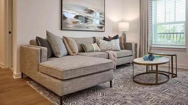 a living room with furniture a rug and a large window