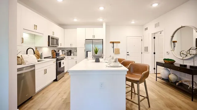 a large kitchen with stainless steel appliances kitchen island granite countertop a sink and cabinets