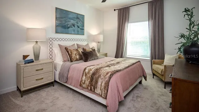 a bedroom with a bed and a potted plant on the dresser