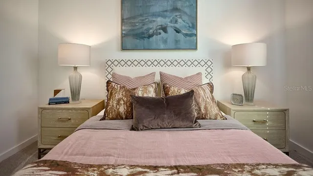 a view of a bedroom with a bed and lamp on dresser