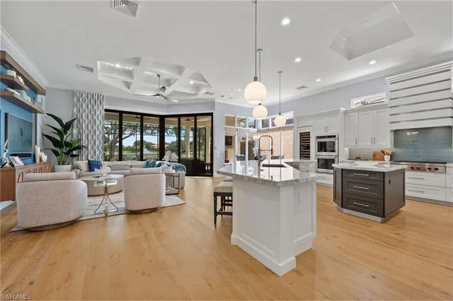 a large white kitchen with lots of counter space and living room view
