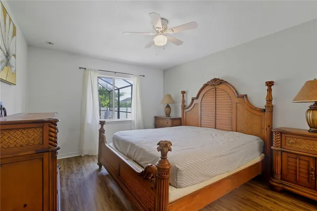 a bedroom with a bed and a dresser with wooden floor