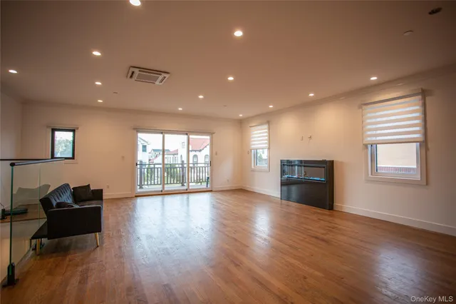 an empty room with wooden floor and natural light