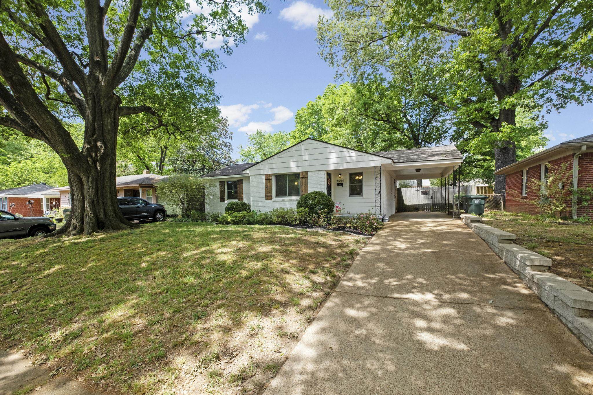 White single-story residence featuring a covered carport and a concrete driveway