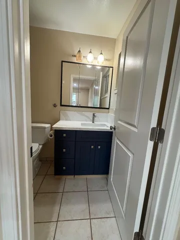a spacious bathroom with a vanity a mirror and bathtub