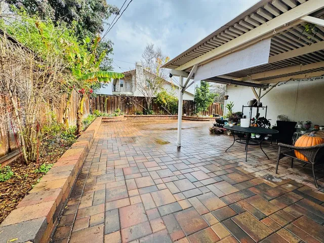 a view of a house with backyard and sitting area