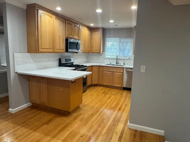 a kitchen with stainless steel appliances granite countertop a stove a sink and a microwave
